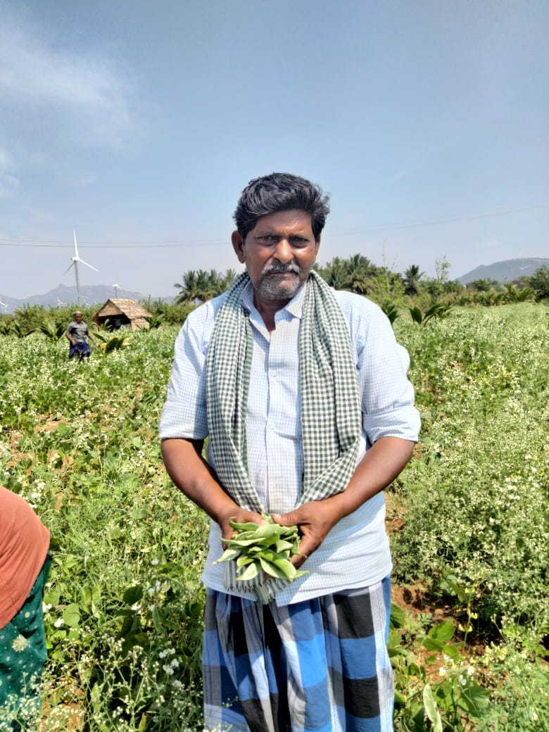 A farmer holding fresh vegetables harvested from his own field